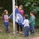 Children raising earth flag